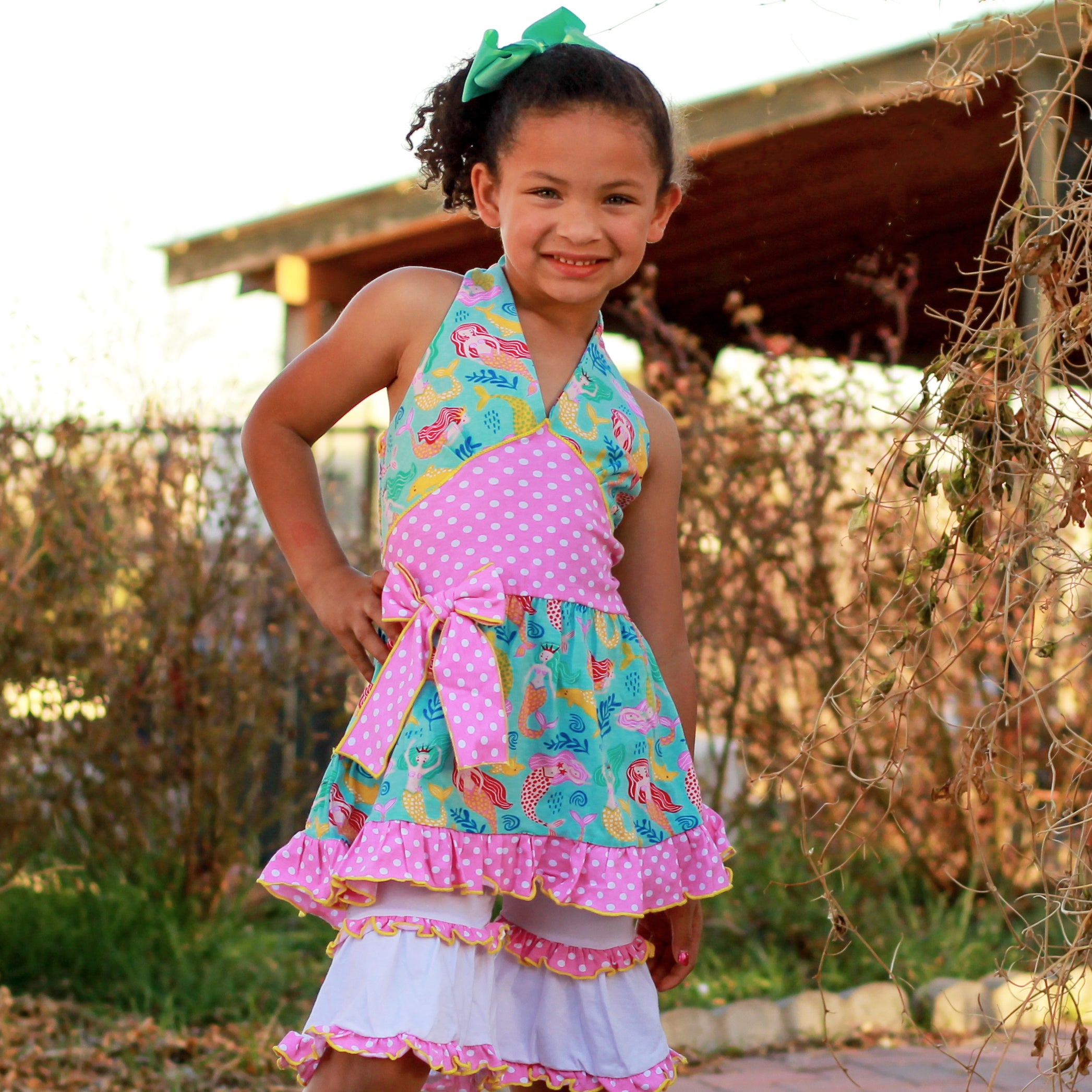 AnnLoren Girls Mermaid Halter Dress featuring a pink polka dot waistband and big bow, paired with white ruffle shorts, perfect for summer wear.